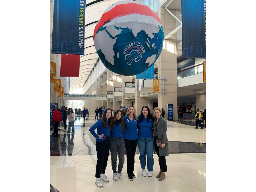 Students standing under large hanging globe