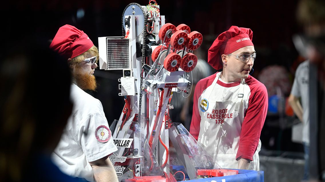 Two students carry a robot