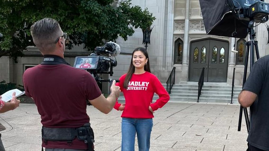 Adalia Yeung talks to the College Tour camera in front of Bradley Hall.