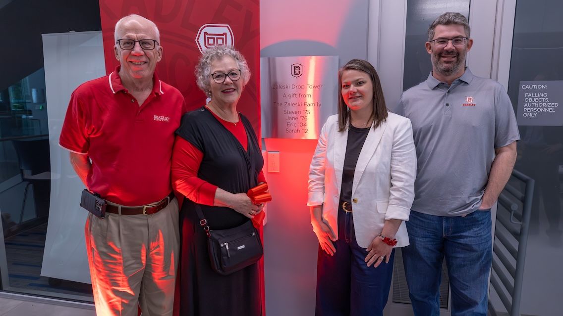 Steve Zaleski ’75, Jane (Turnbull) Zaleski ’76, Sarah (Zaleski) Degarmo ’12 and Eric Zaleski ’04 stand in front of the drop tower in the Business and Engineering Convergence Center