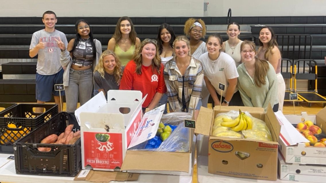 Bradley volunteers pose behind some of the healthy produce they're selling through Market 309.