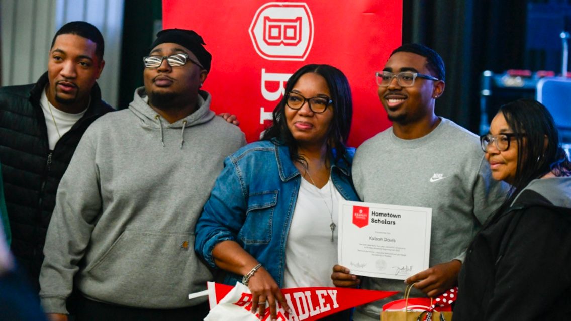 Hometown Scholarship recipient Kaizon Davis poses with his family after being surprised at school with the award