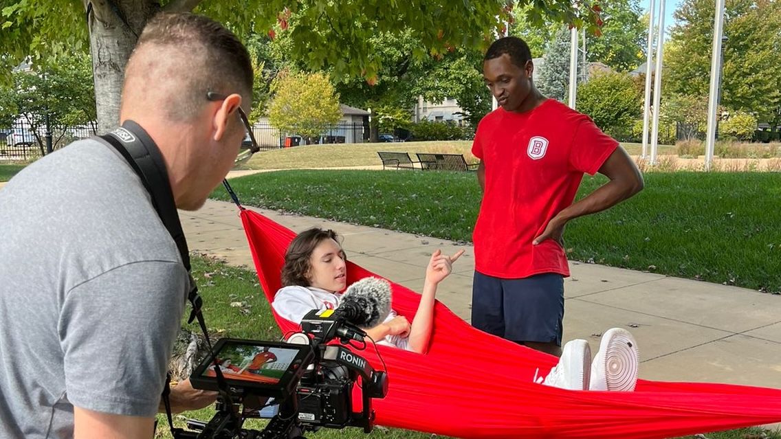 Kyle Irish-Hall talks with a friend from the hammocking club while a videographer from The College Tour captures their conversation.