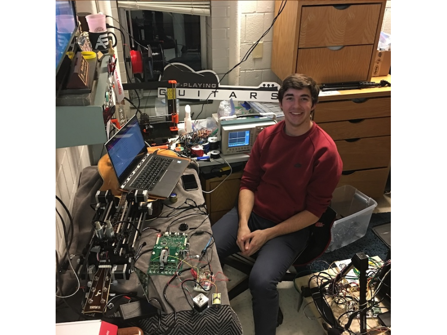 Kuzma in his dorm room at Bradley University, working on his self-playing robotic guitar