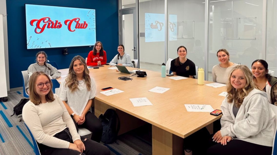 Members of Bradley University's Girls Club sit around a table during one of their regular meetings.