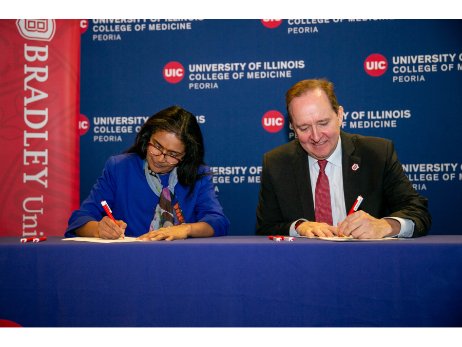 Regional Dean of UICOMP, Dr. Meenakshy Aiyer and Bradley University President Stephen Standifird sign the EAP agreement.